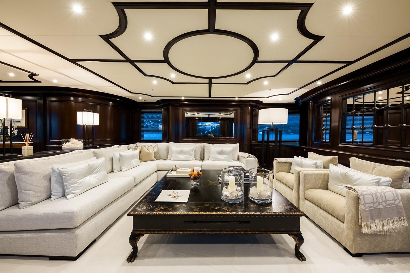 a living room with a large sofa and a table aboard ELENI Yacht for Sale
