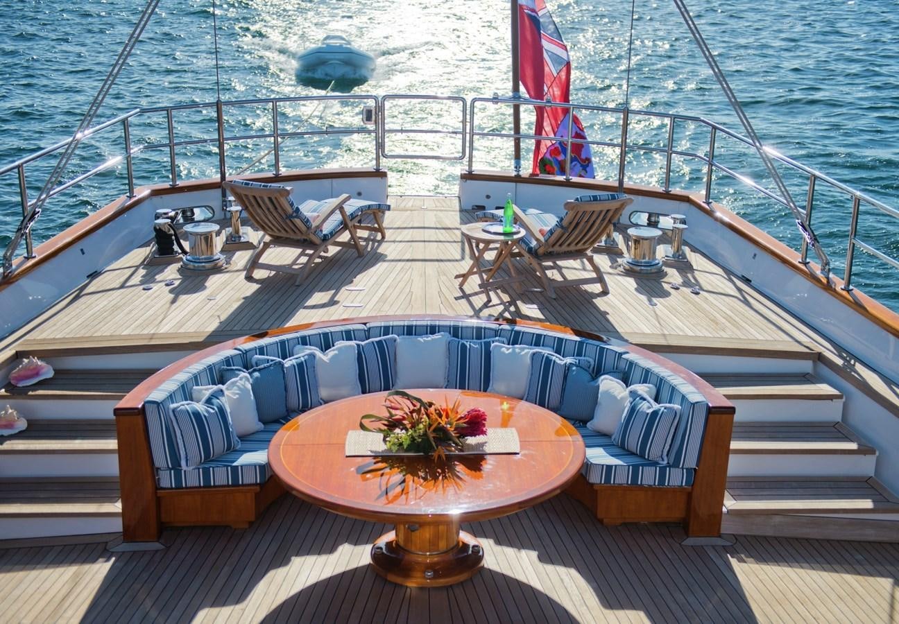 a deck with a table and chairs on it aboard MORNING GLORY Yacht for Sale