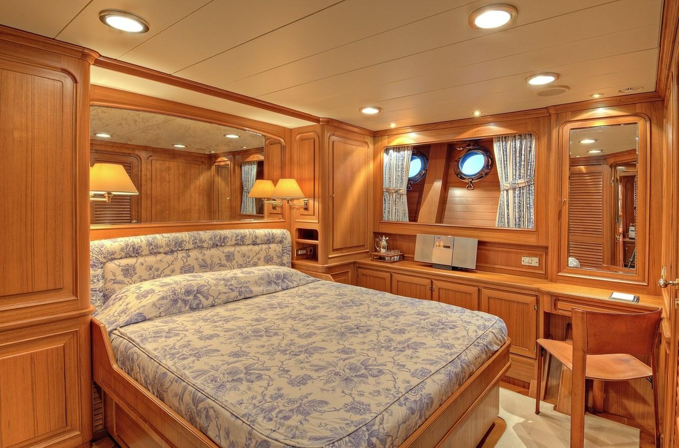 a large bedroom with wood walls aboard MORNING GLORY Yacht for Sale