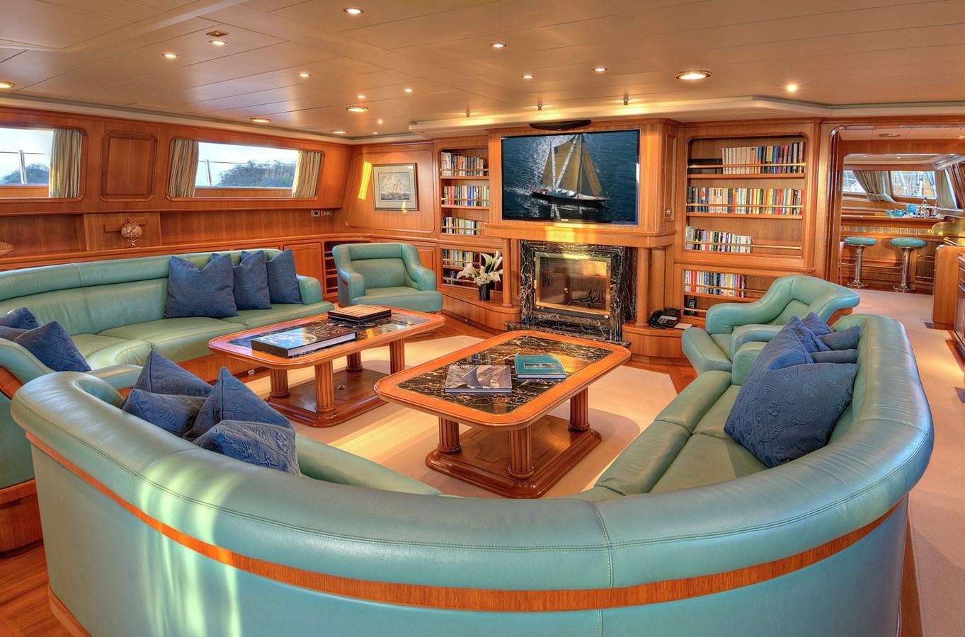 a living room with a blue couch and a fireplace aboard MORNING GLORY Yacht for Sale