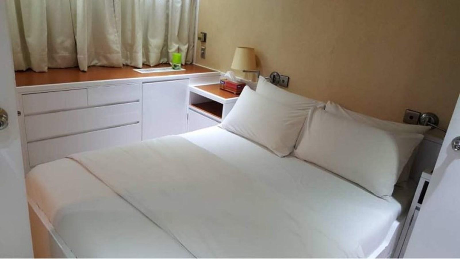 a bed with white sheets aboard LANGKAWI LADY Yacht for Sale