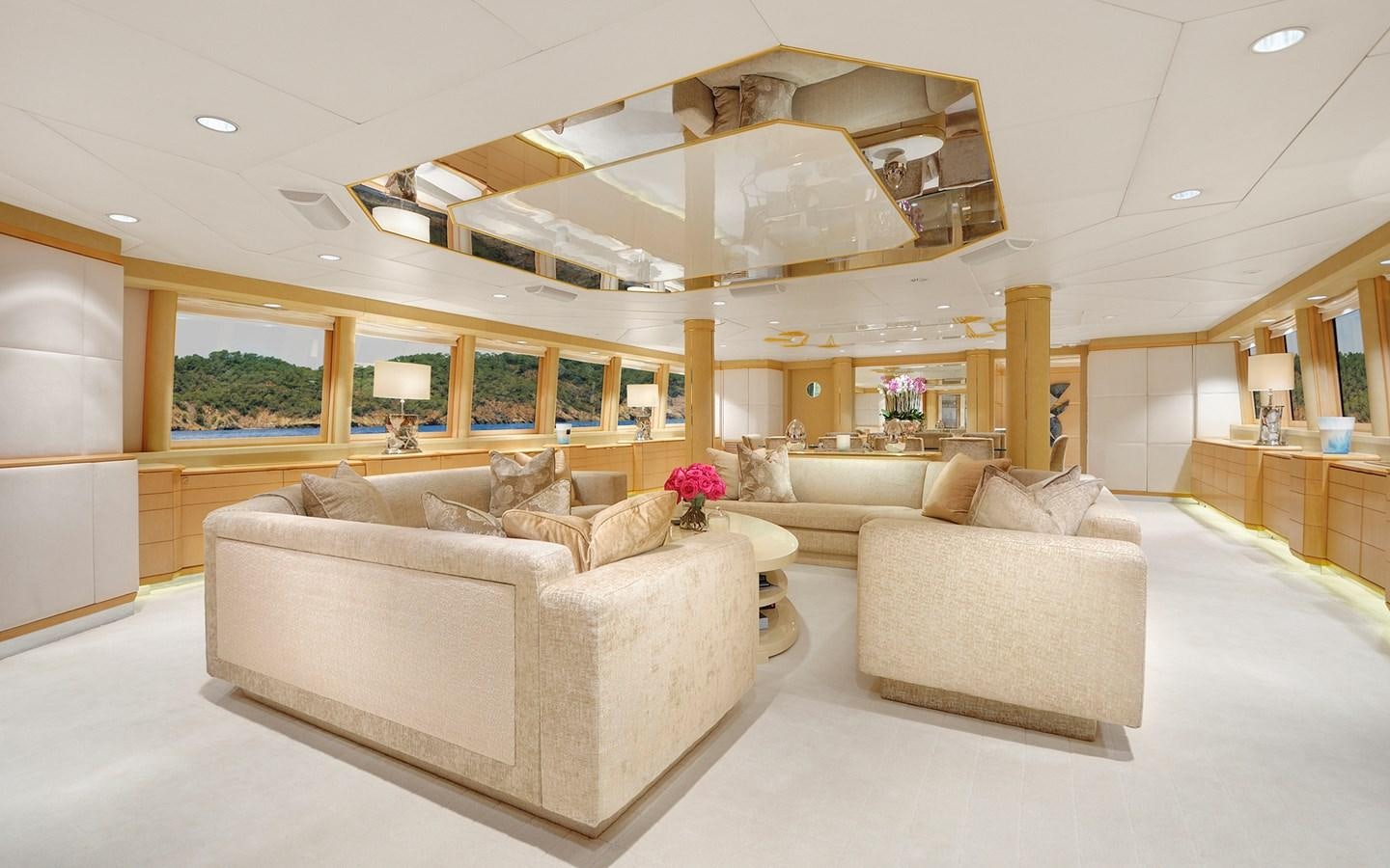a living room with a large white couch and a large chandelier aboard AZZURRA II Yacht for Sale