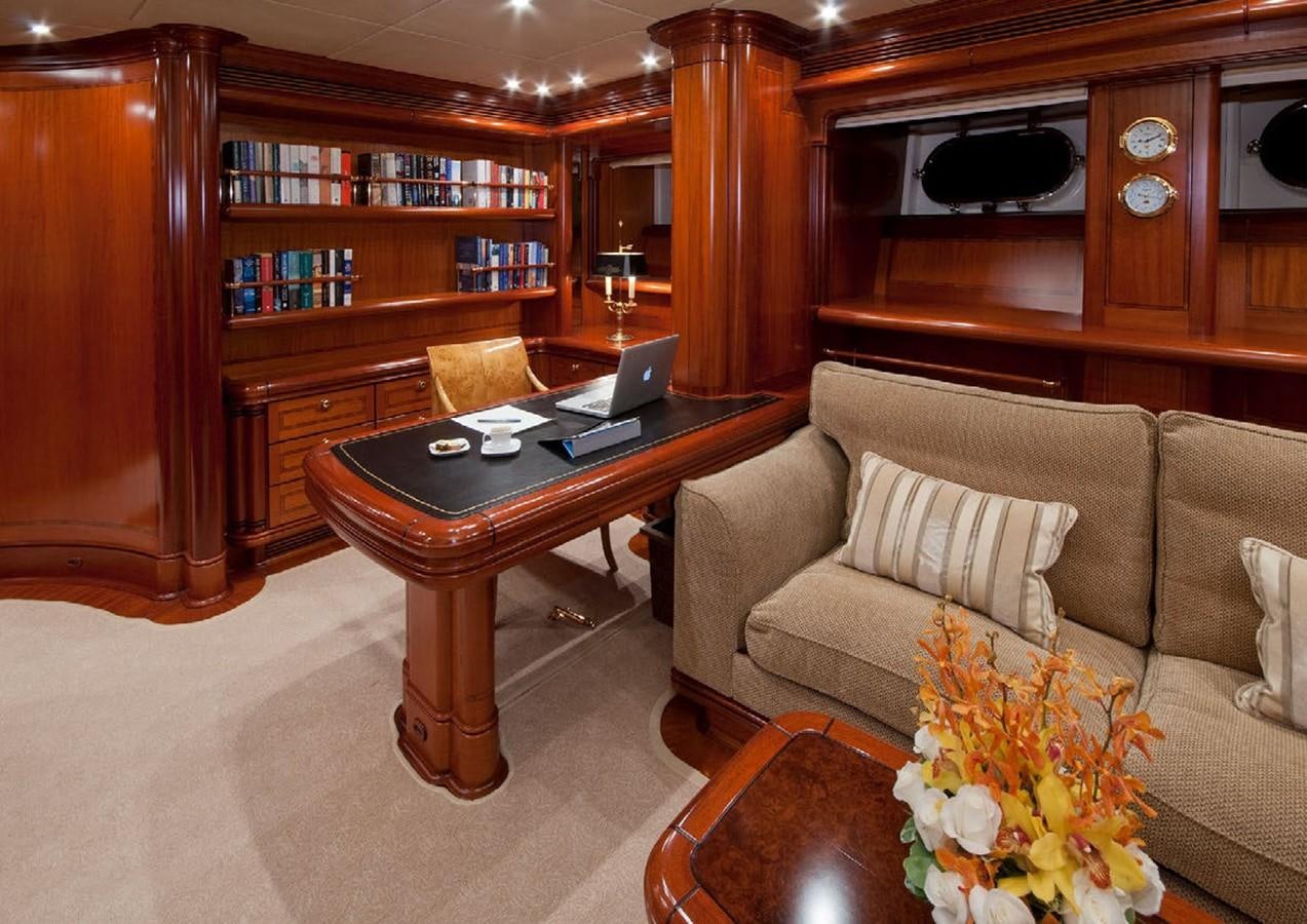 a living room with a laptop on a coffee table aboard HYPERION Yacht for Sale