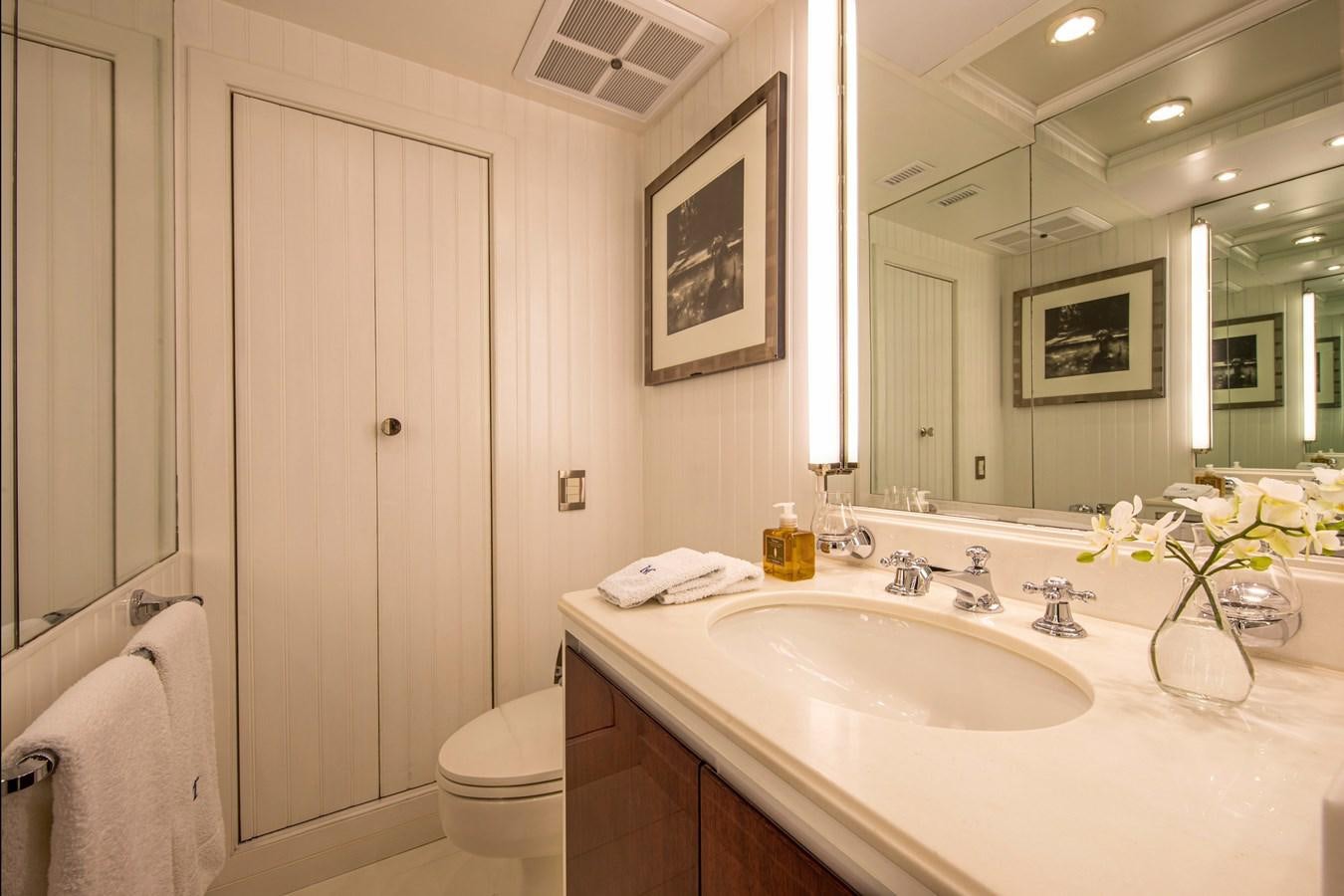 a bathroom with a sink toilet and a mirror aboard MIKADO Yacht for Sale