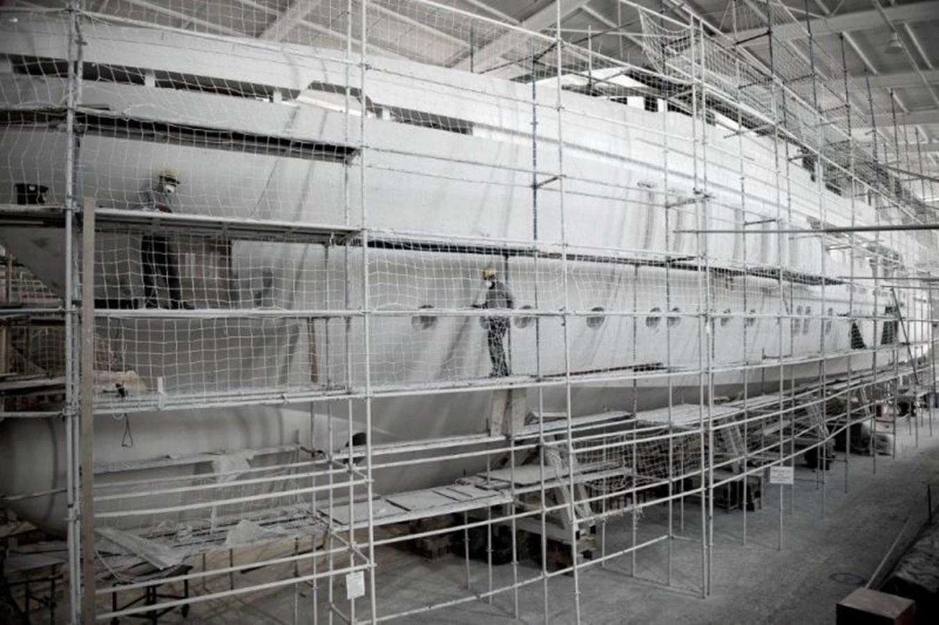 a large white factory with a few people standing in it aboard HULL#05 Yacht for Sale