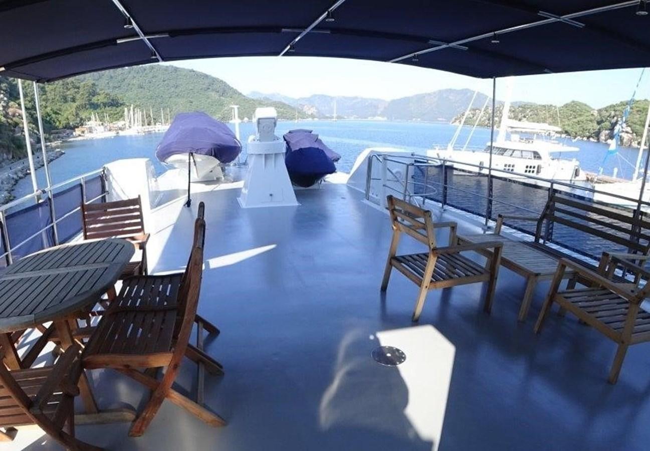 a deck with chairs and umbrellas aboard AGA 6 Yacht for Sale