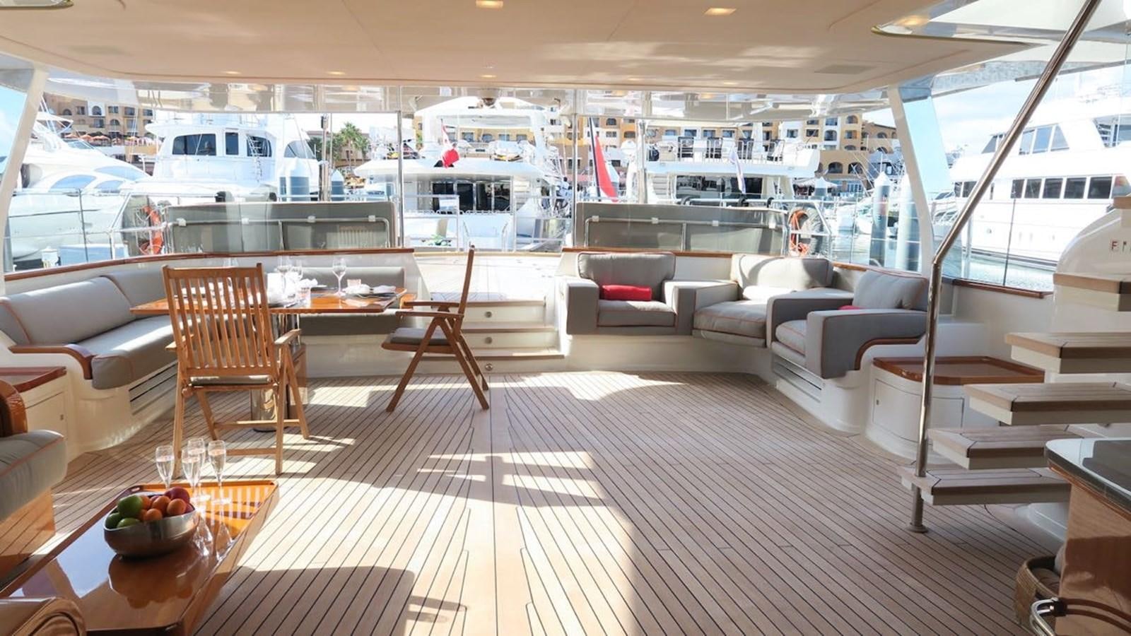 a room with a table chairs and a boat in the background aboard SERENDIPITY I Yacht for Sale
