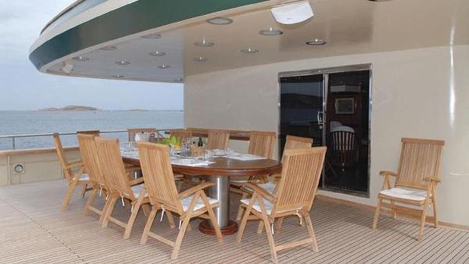 a dining table and chairs on a deck aboard ARIETE PRIMO Yacht for Sale