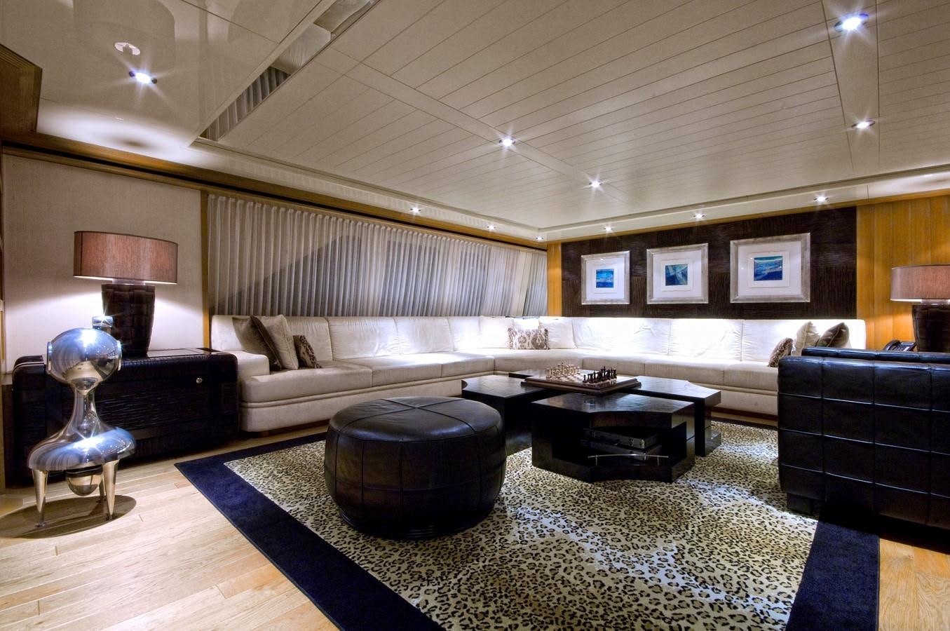 a large living room with a large sofa and a large window aboard KIJO Yacht for Charter