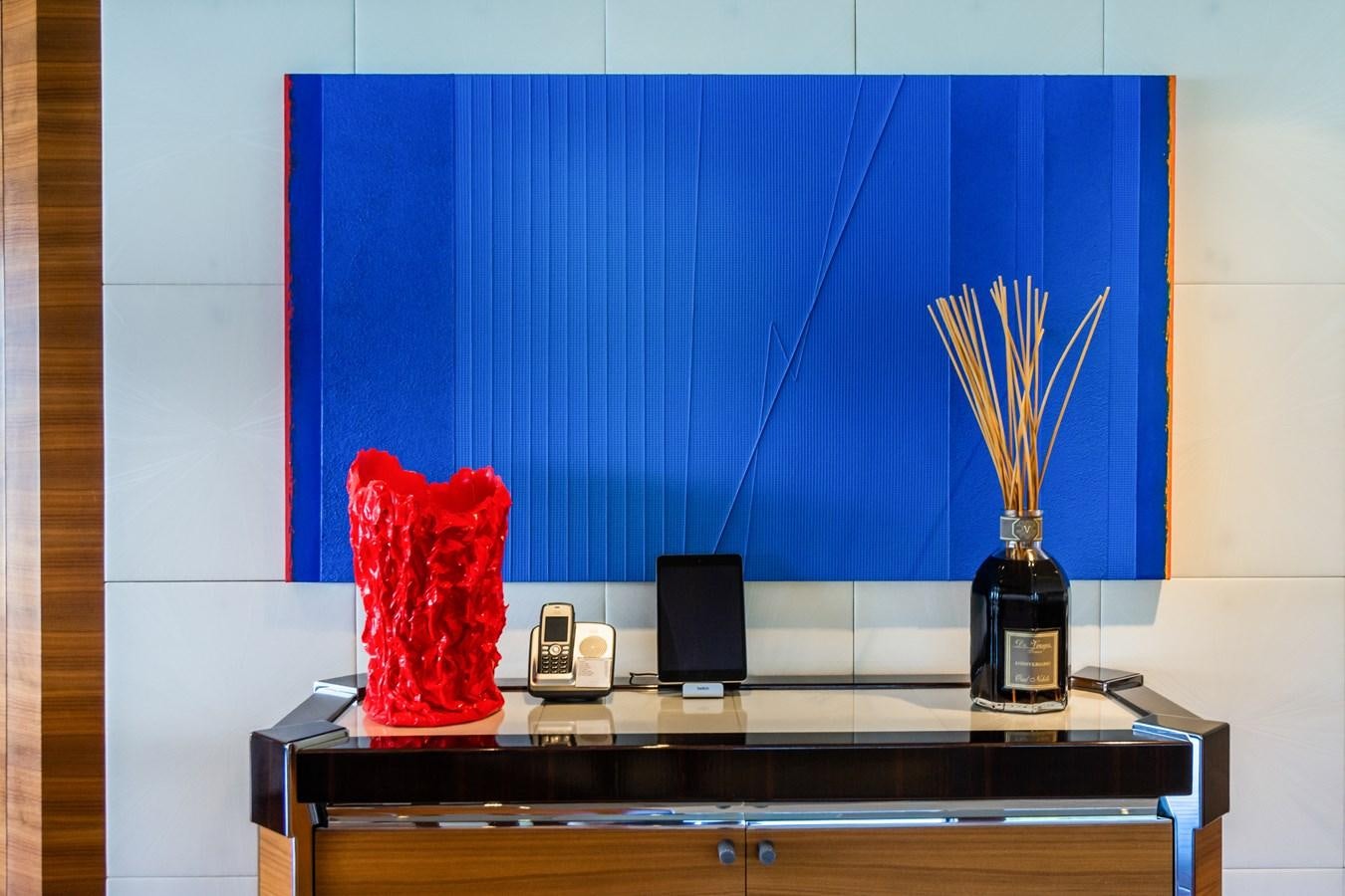 a desk with a bottle of wine and a painting on it aboard SILVER WIND Yacht for Sale