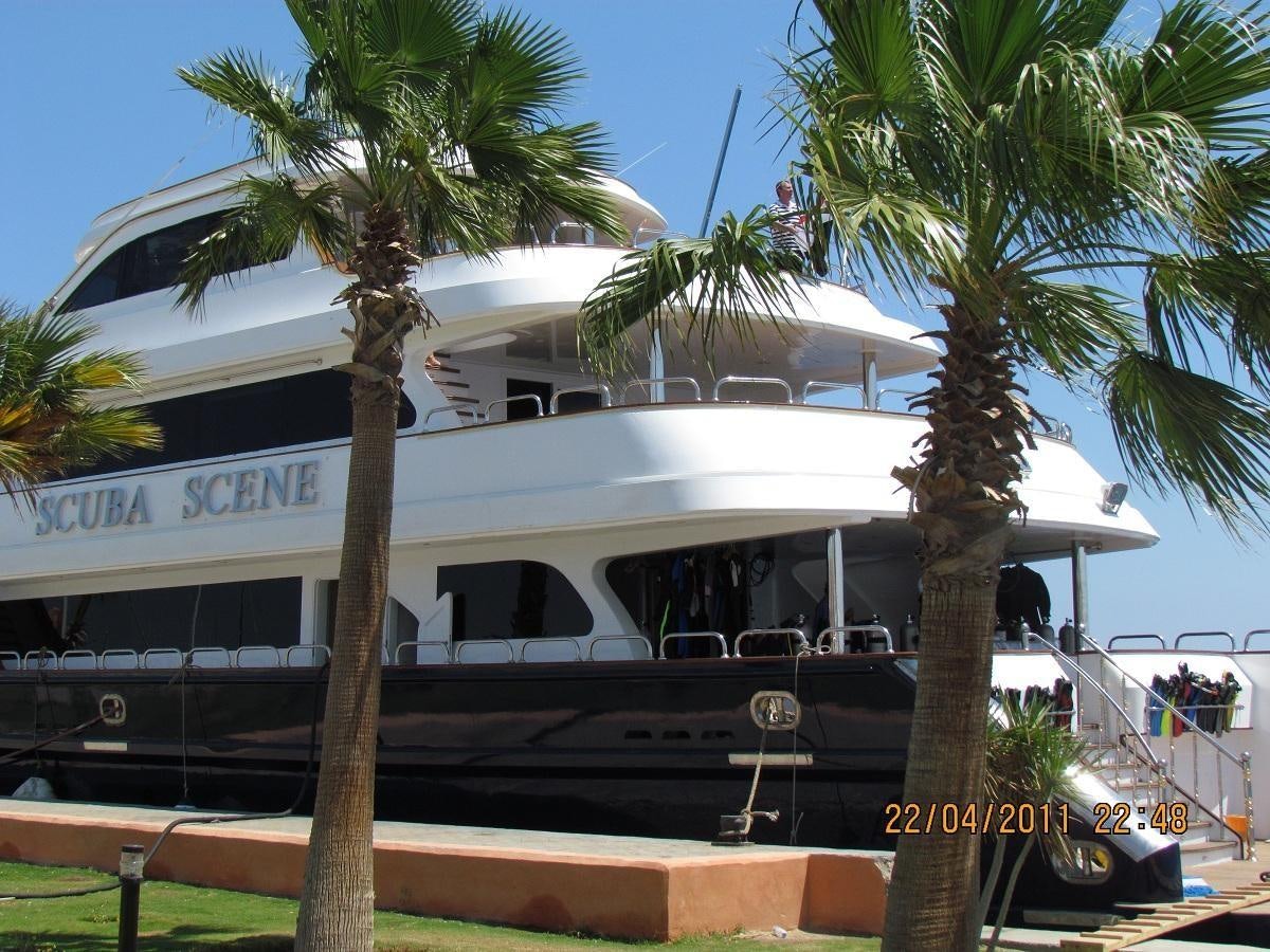 a white building with palm trees aboard SCUBA SCENE Yacht for Sale