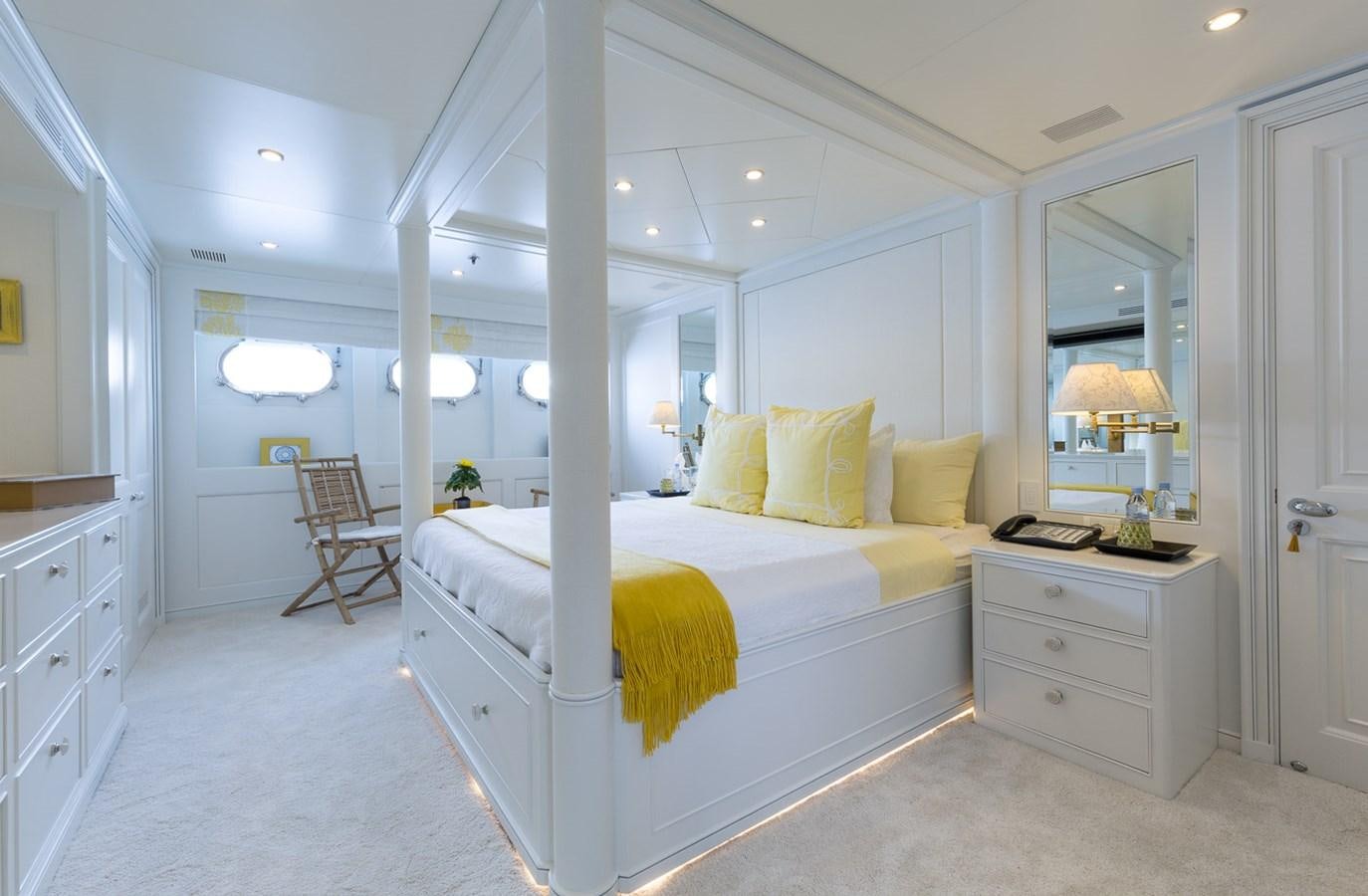 a large white bedroom with a large bed and a large mirror aboard BINA Yacht for Sale