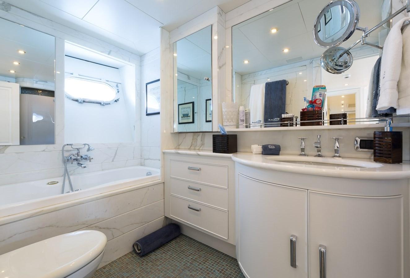 a bathroom with a tub sink and cabinets aboard BINA Yacht for Sale