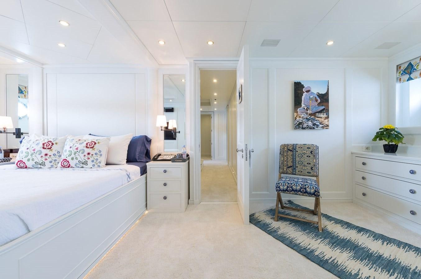 a bedroom with a bed and a chair aboard BINA Yacht for Sale