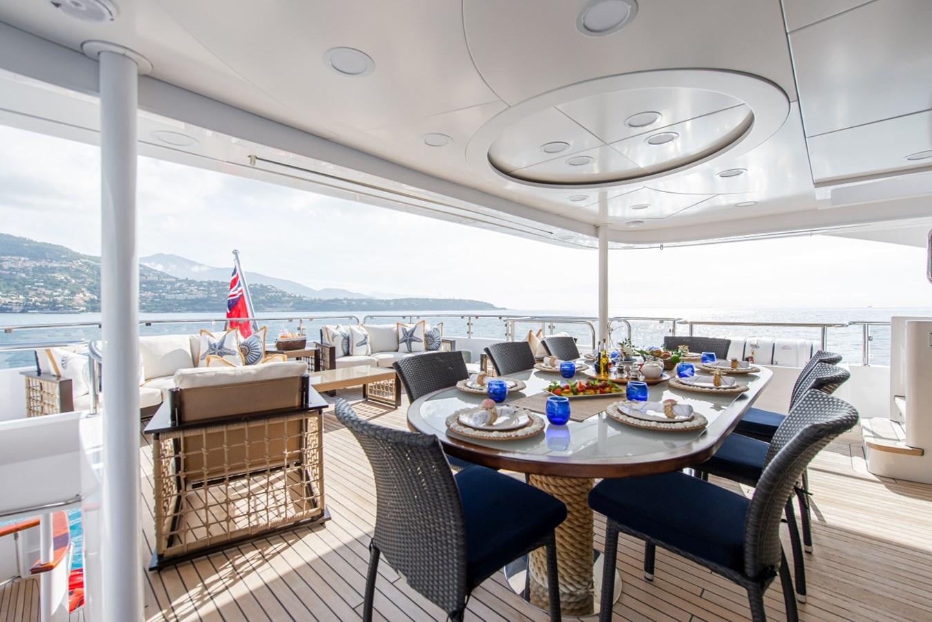 a table with chairs and a view of the water aboard BINA Yacht for Sale