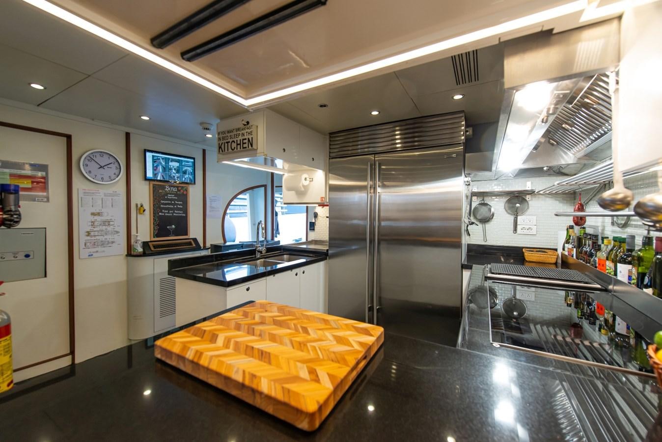a kitchen with a large stainless steel refrigerator aboard BINA Yacht for Sale