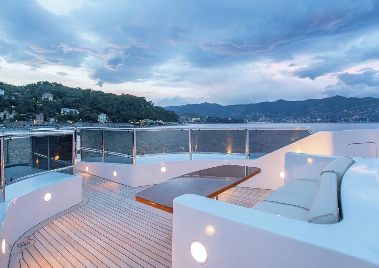 a deck with a view of the water and mountains in the background aboard DIANE Yacht for Sale
