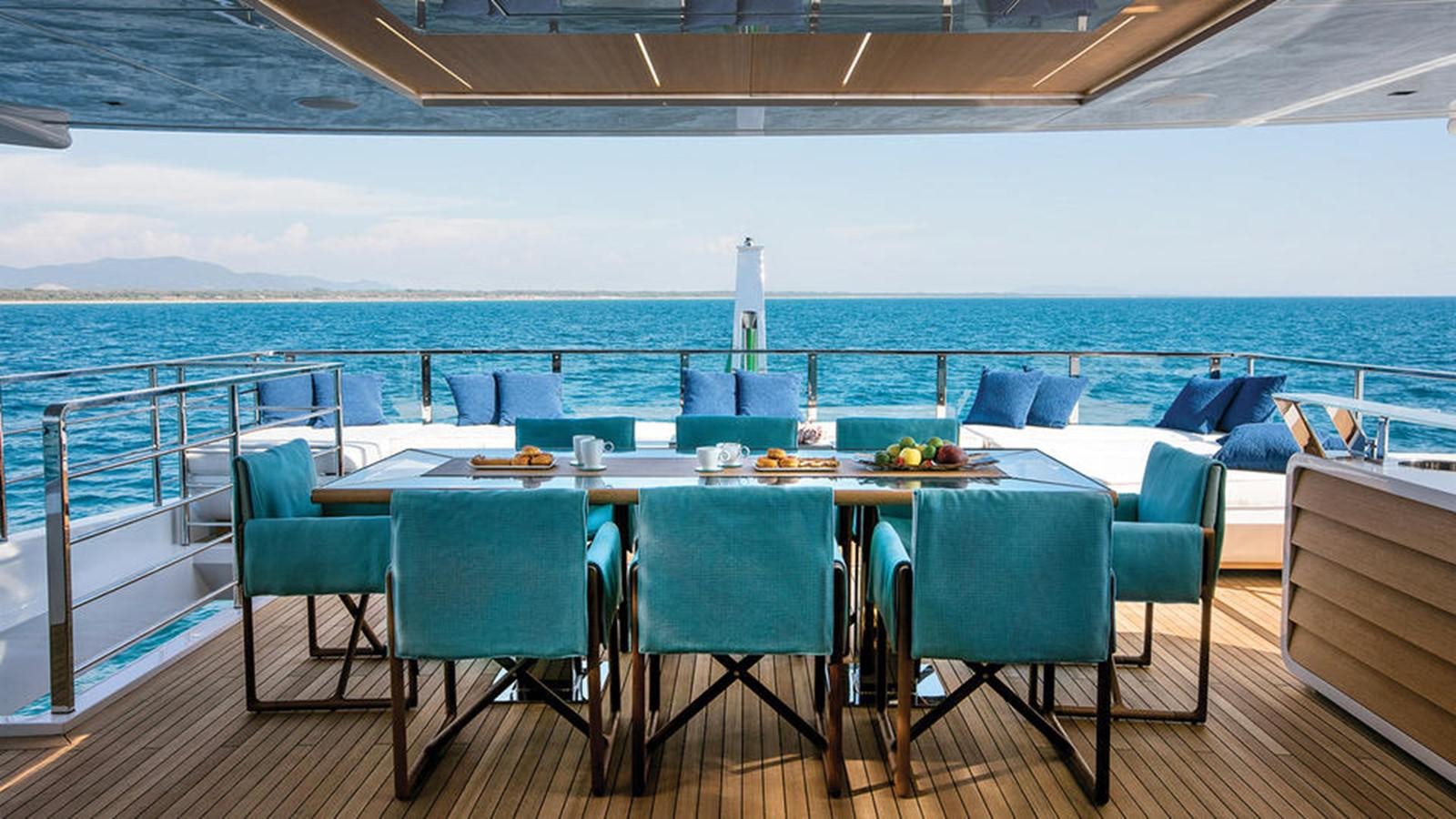 a table and chairs on a deck overlooking a body of water aboard NAMASTE Yacht for Charter