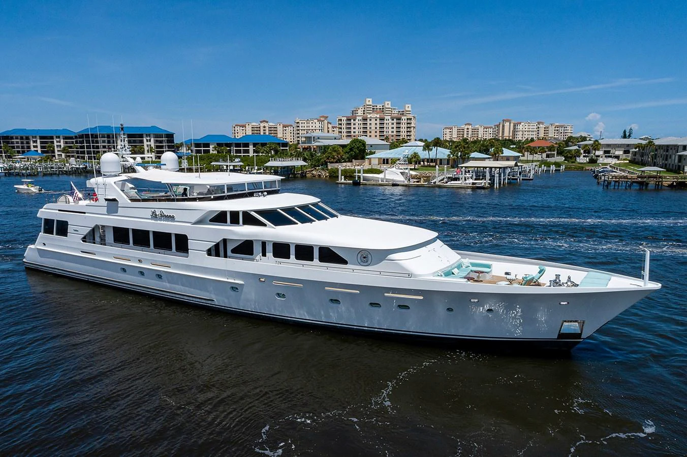 a large white boat in a harbor aboard LA SIRENA Yacht for Sale