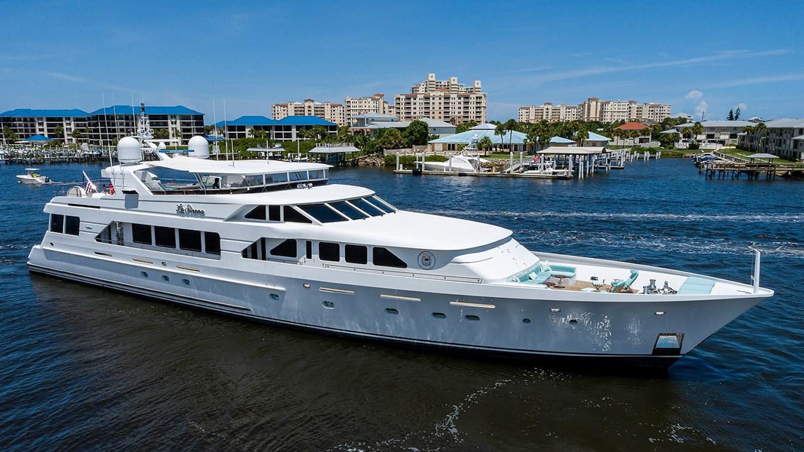 a large white boat in a harbor aboard LA SIRENA Yacht for Sale