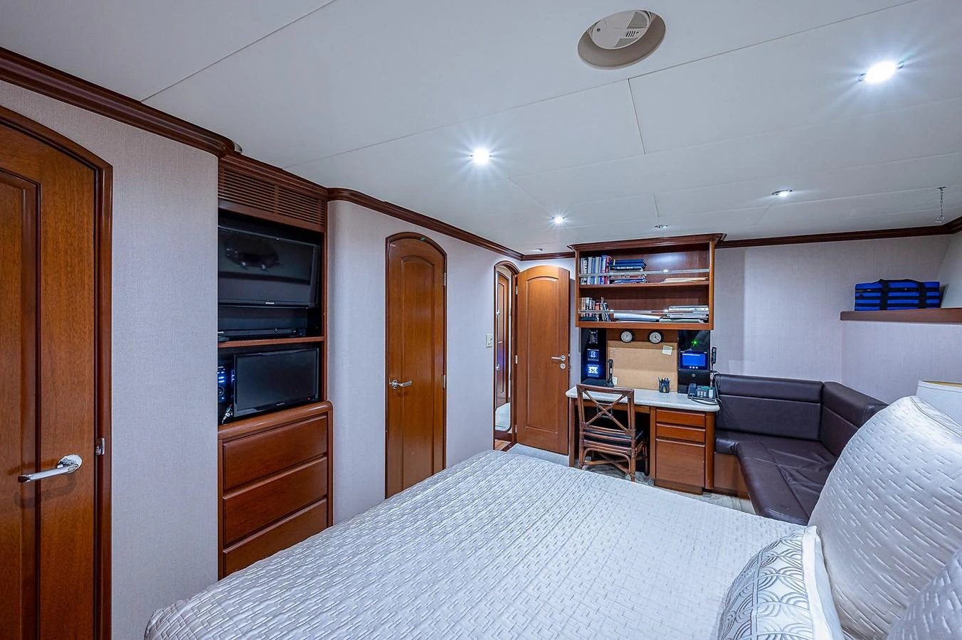 a bedroom with a bed and a desk aboard LA SIRENA Yacht for Sale