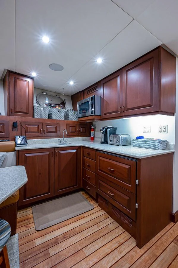 a kitchen with wooden cabinets aboard LA SIRENA Yacht for Sale