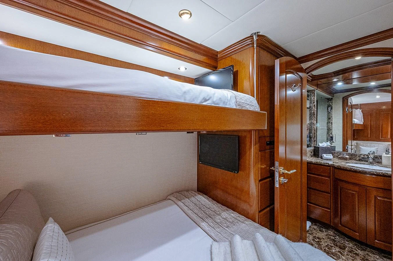 a bedroom with a bed and a wood door aboard LA SIRENA Yacht for Sale