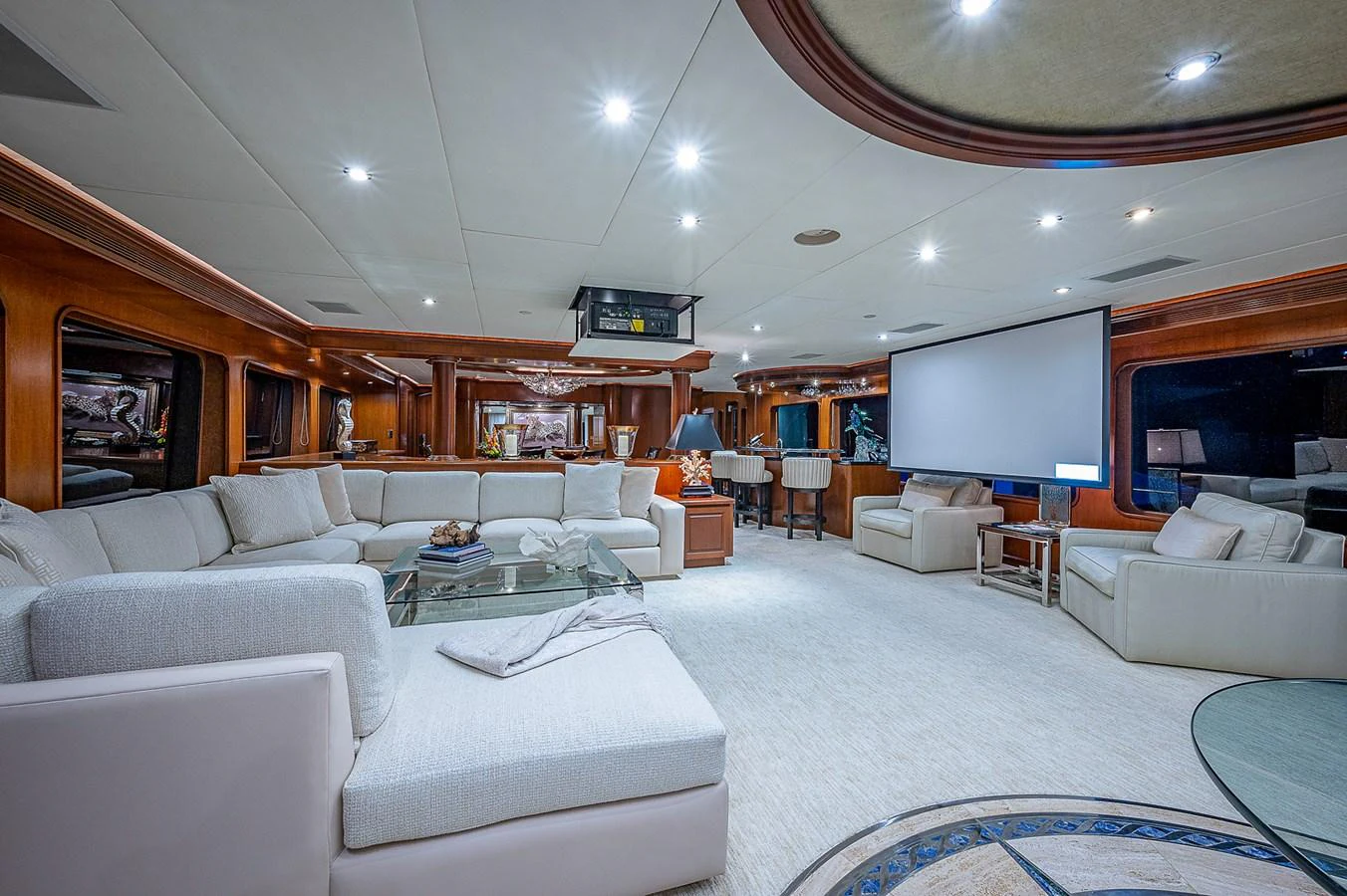 a living room with a large white couch and a large screen aboard LA SIRENA Yacht for Sale