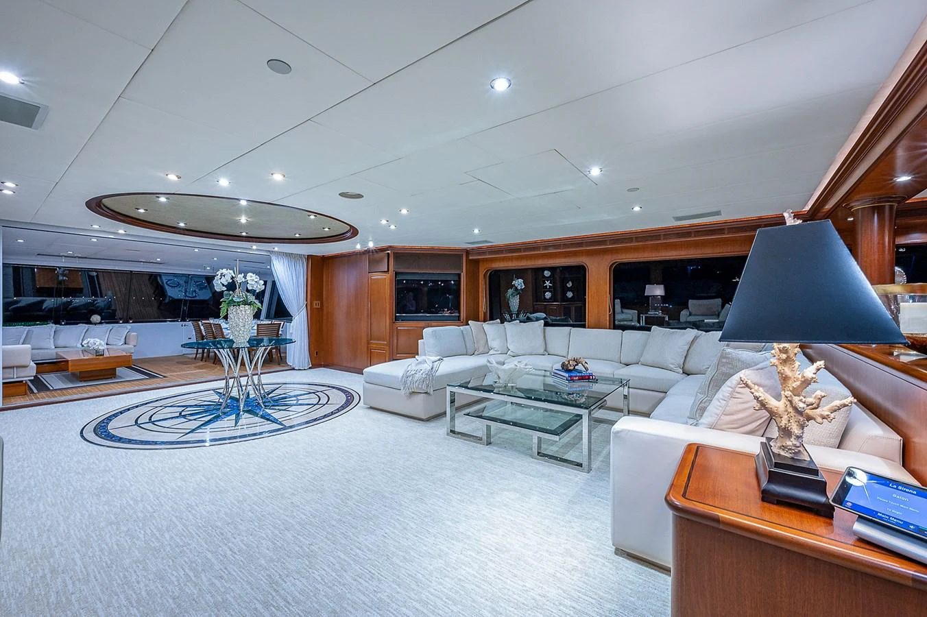 a living room with a large white rug and a large chandelier aboard LA SIRENA Yacht for Sale