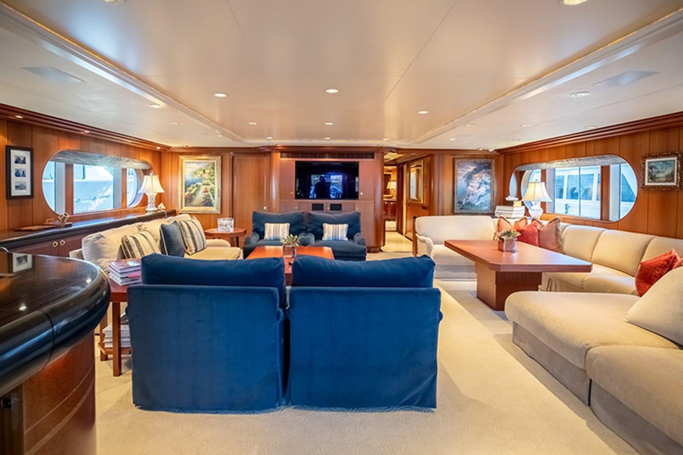 a living room with blue chairs and a fireplace aboard NEVER ENOUGH Yacht for Sale