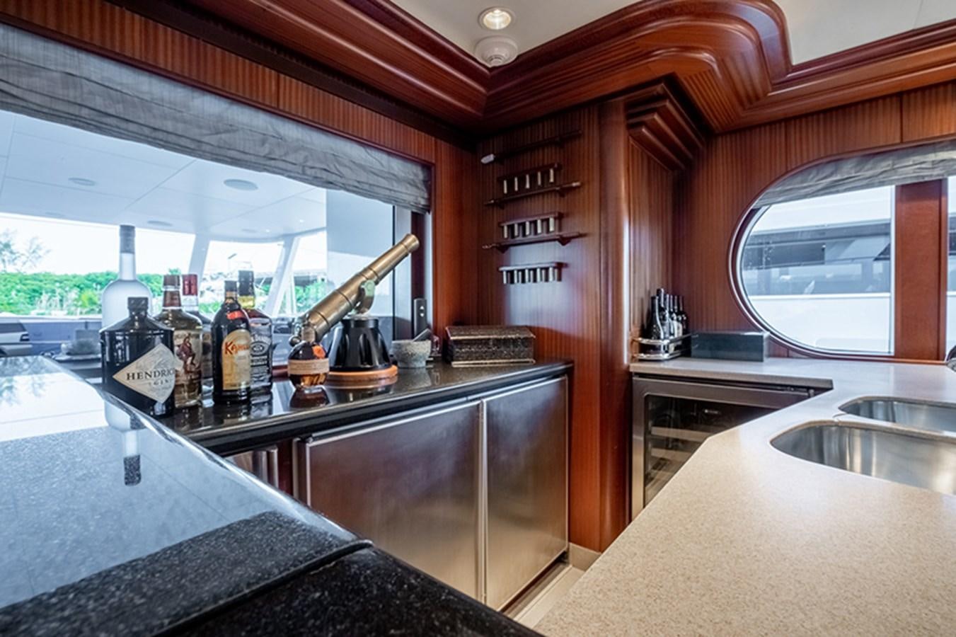 a kitchen with a bar and a large window aboard NEVER ENOUGH Yacht for Sale