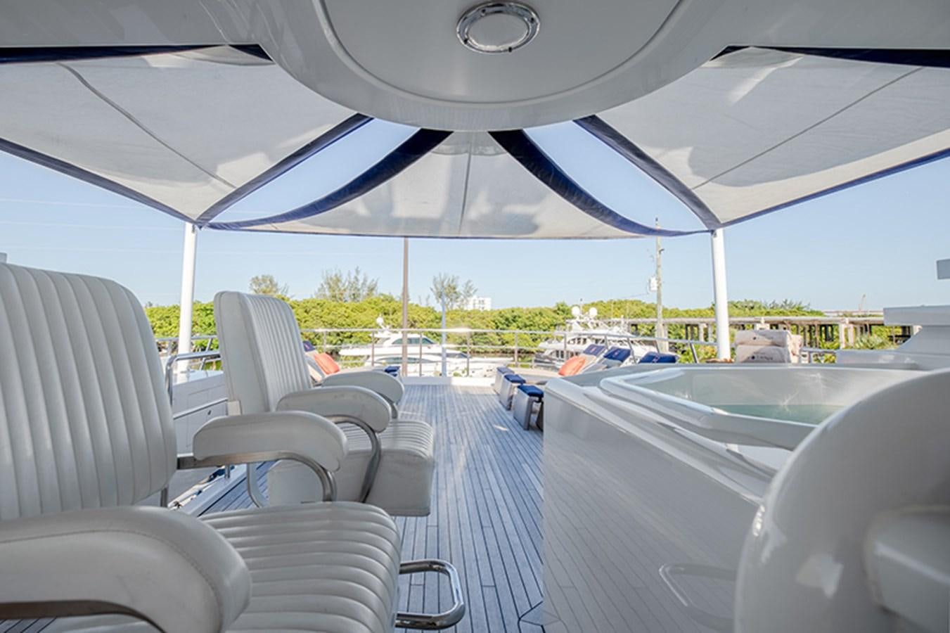 inside of a vehicle with chairs and a large tent with a view of the beach and trees and aboard NEVER ENOUGH Yacht for Sale