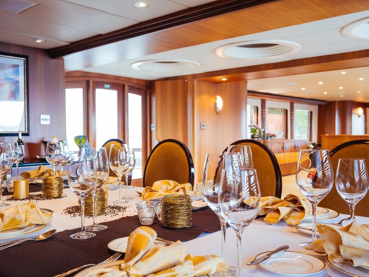a table with food and wine glasses aboard DAYDREAM Yacht for Sale