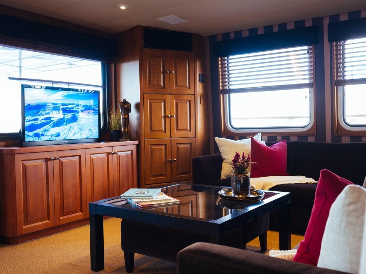 a living room with a table and couches aboard DAYDREAM Yacht for Sale