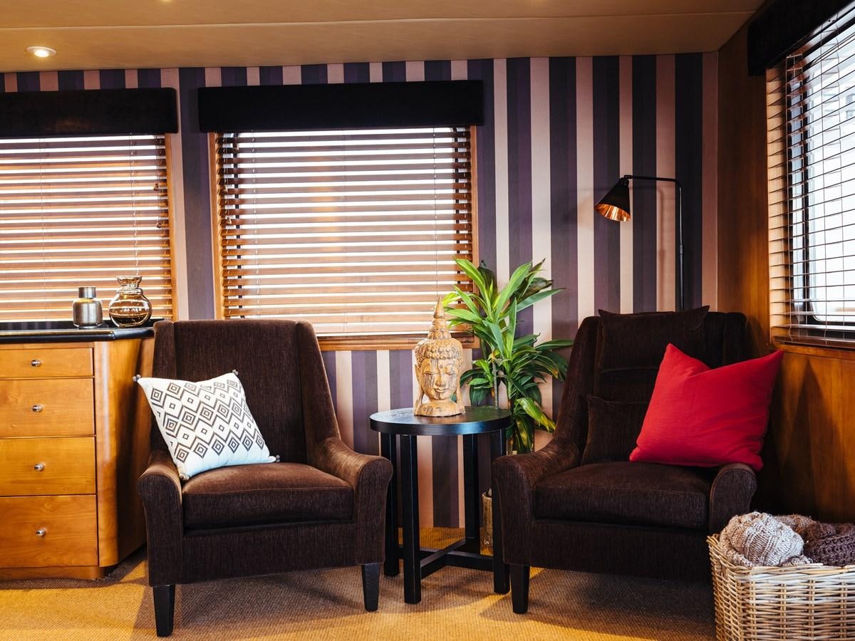 a living room with black and red furniture aboard DAYDREAM Yacht for Sale