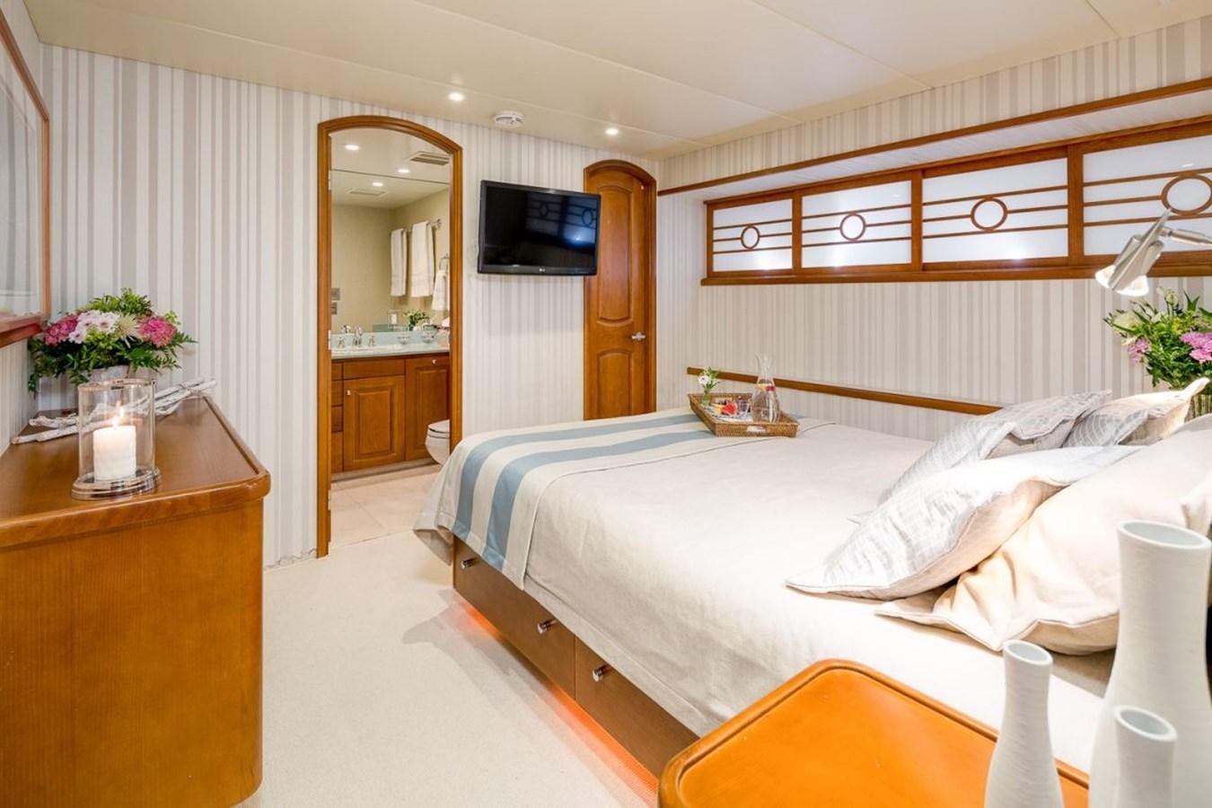 a bedroom with a bed and a television aboard DAYDREAM Yacht for Sale