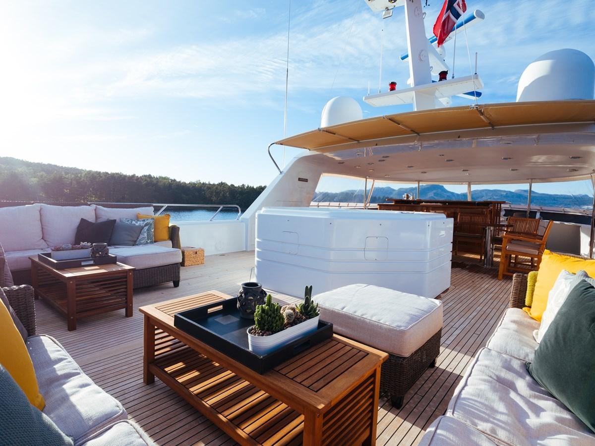a living room with a table and couches aboard DAYDREAM Yacht for Sale