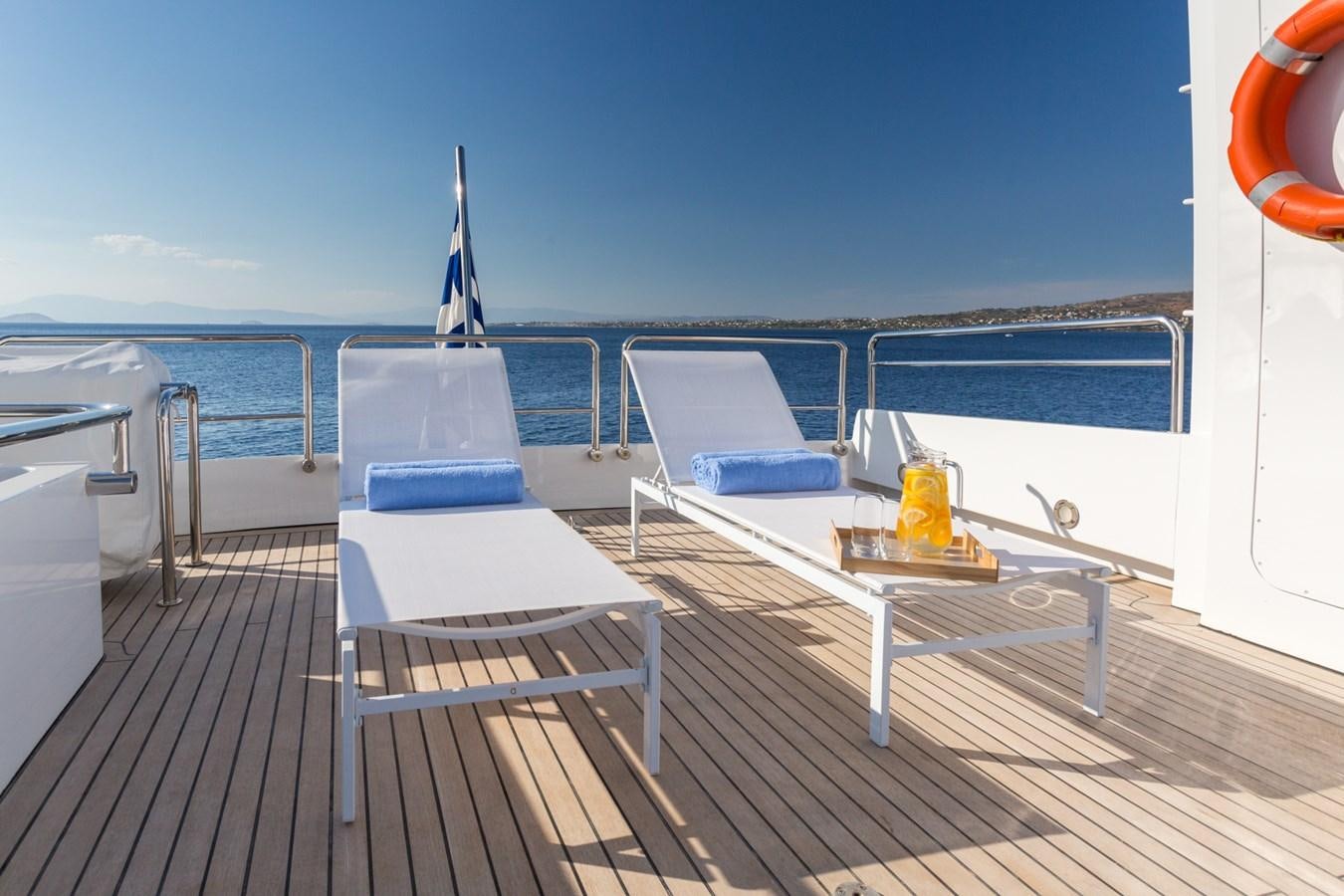 a deck with chairs and a table on it aboard AQUARELLA Yacht for Sale