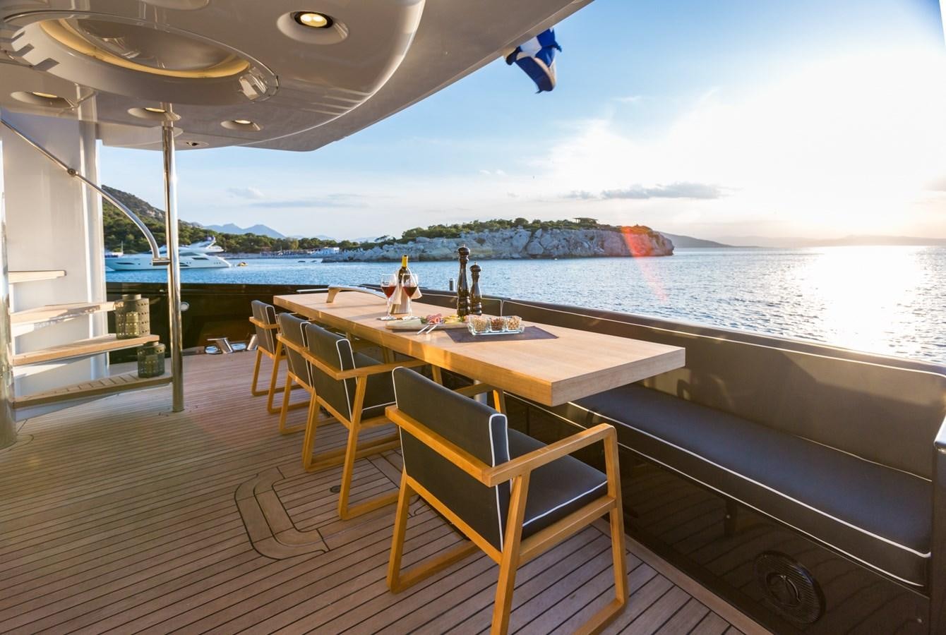 a table and chairs on a deck overlooking a body of water aboard AQUARELLA Yacht for Sale