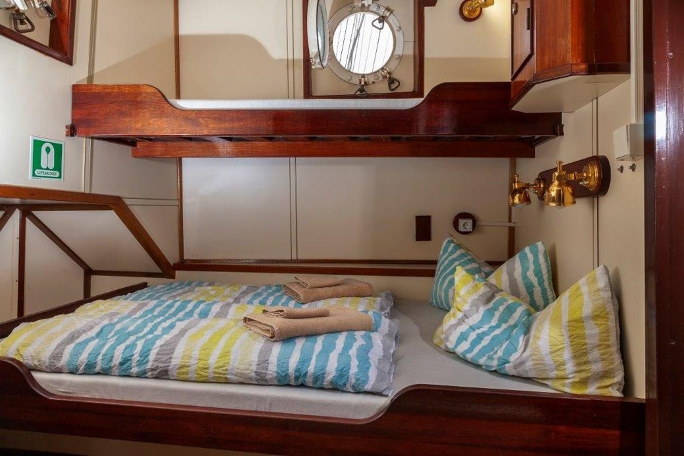 a bed with a mirror above it aboard SIR ROBERT BADEN POWELL Yacht for Sale