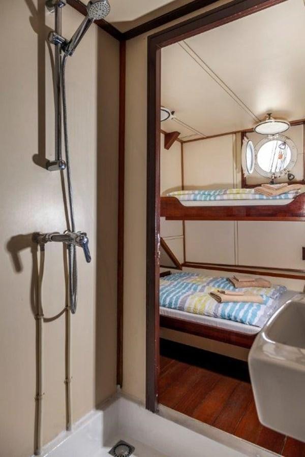 a room with a bed and a lamp aboard SIR ROBERT BADEN POWELL Yacht for Sale