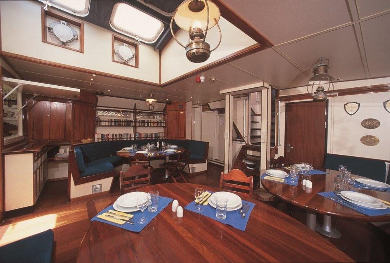 a living room with a wood table and a couch aboard SIR ROBERT BADEN POWELL Yacht for Sale