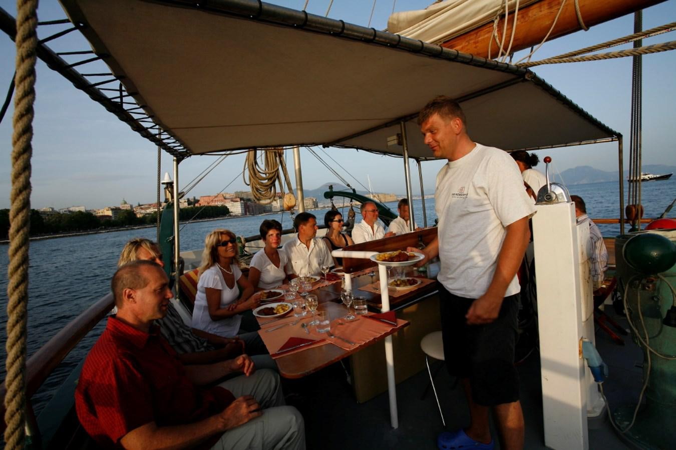 a group of people sitting at a table on a boat aboard SIR ROBERT BADEN POWELL Yacht for Sale