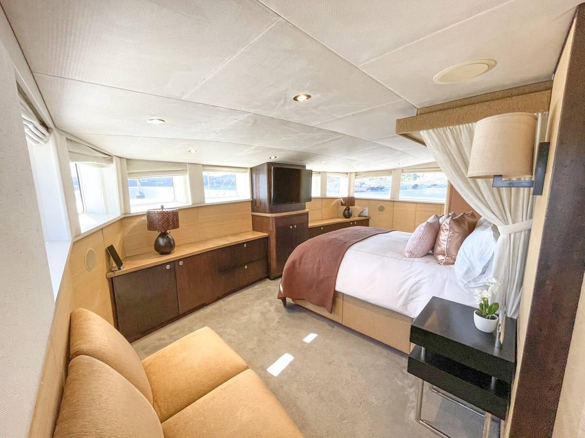 a bedroom with a bed and a desk aboard ENVY Yacht for Sale
