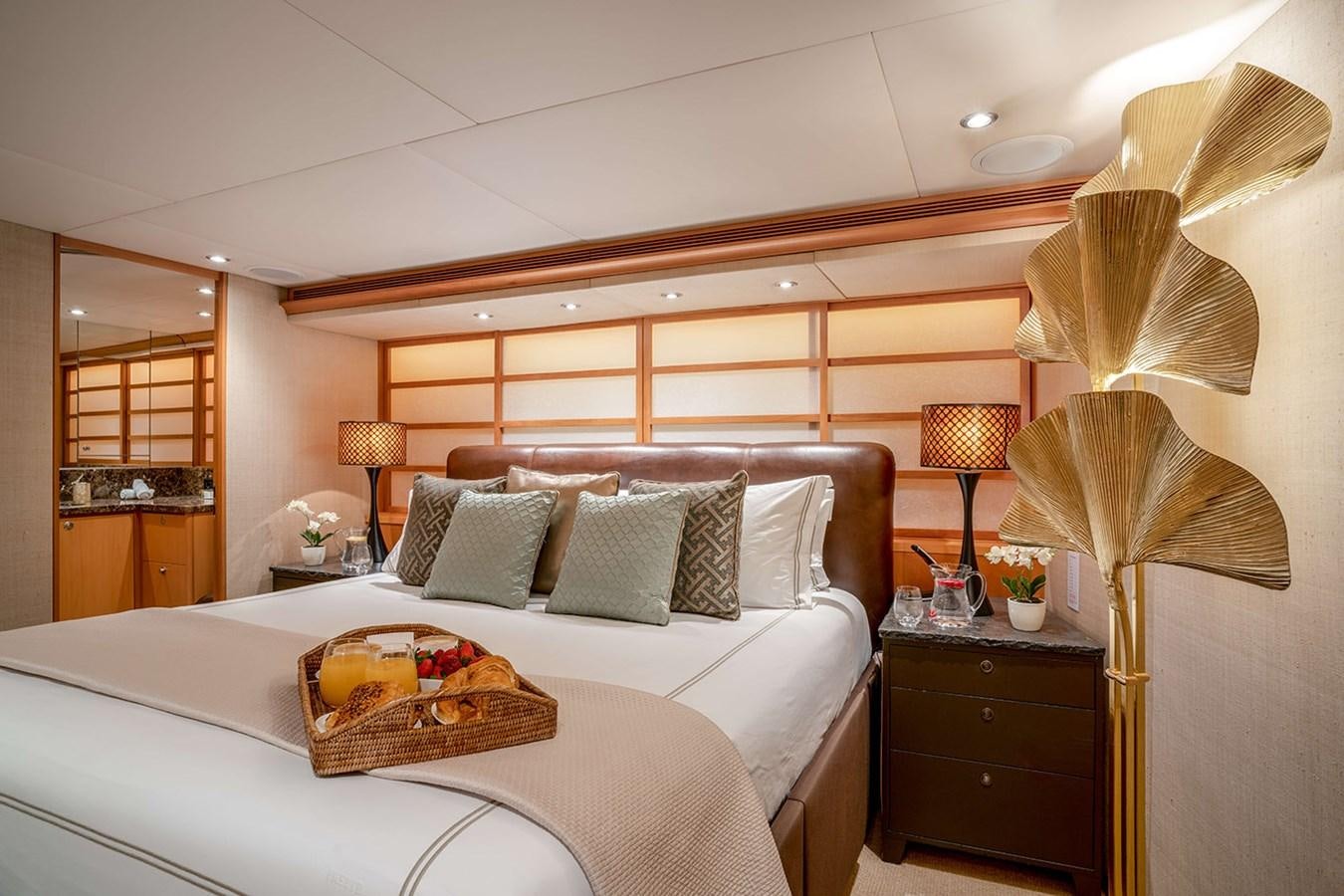 a bed with a white bed spread aboard ENVY Yacht for Sale