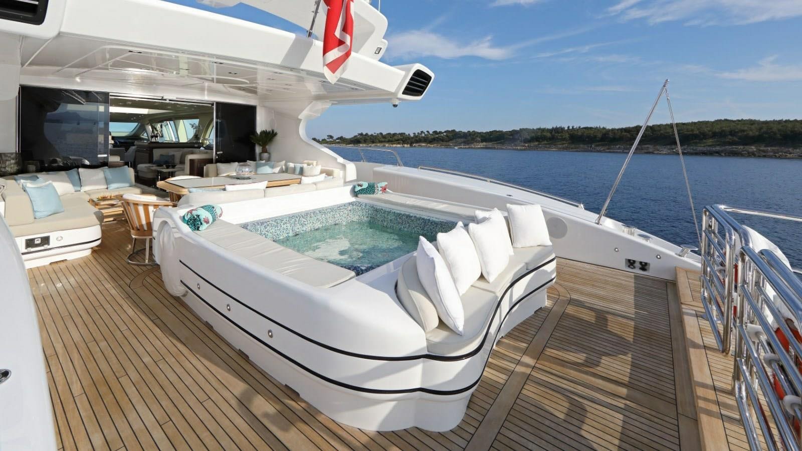 a deck with a pool and a deck with chairs and a boat on it aboard YOU & G Yacht for Sale