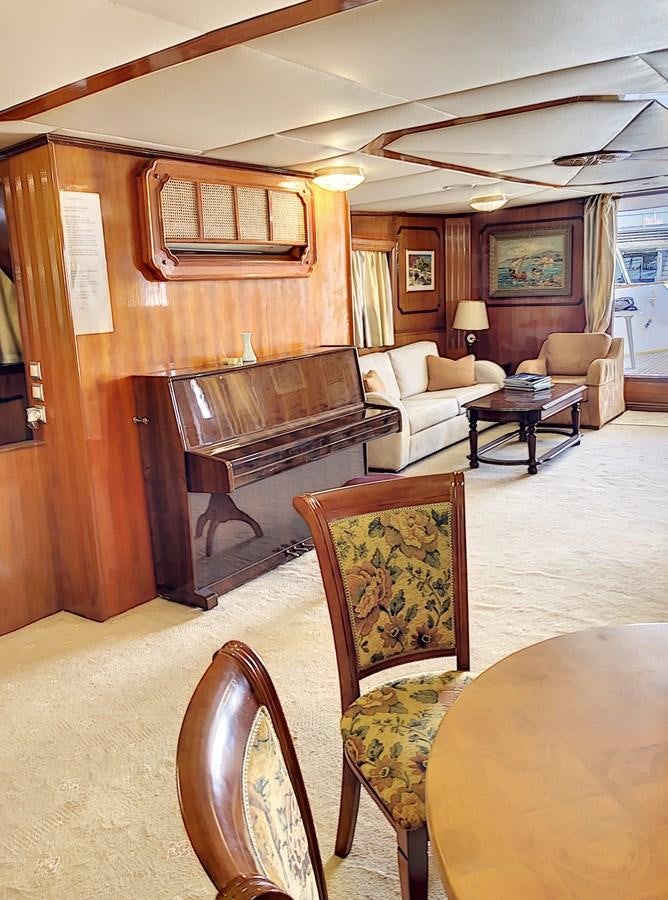 a living room with a piano aboard ELIKI Yacht for Sale
