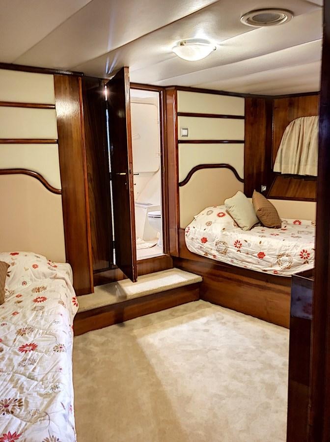 a bedroom with a couple of beds aboard ELIKI Yacht for Sale