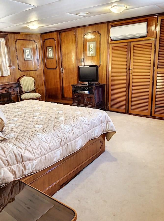 a bedroom with a bed and a tv aboard ELIKI Yacht for Sale