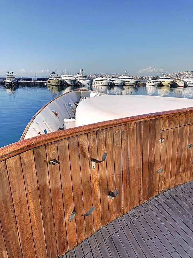 a wooden fence next to a body of water with boats in it aboard ELIKI Yacht for Sale